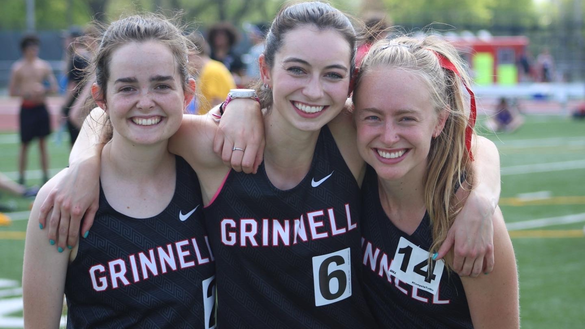 My friends and I smile and put our arms around each other at a Track & Field Conference in 2022