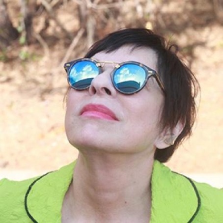 LeAnne Howe wearing sunglasses looking up in the sky.