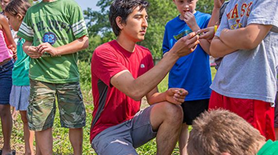Student teaching children how to garden