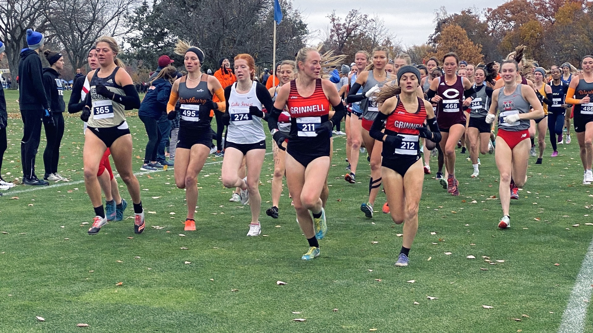 My teammates and I run on the green grass for XC Regionals 2021